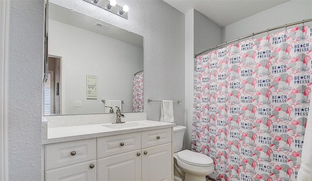 bathroom with vanity, walk in shower, and toilet