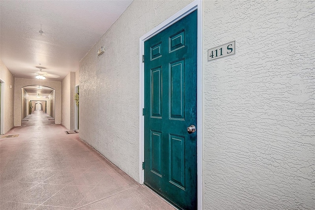 hall with a textured ceiling