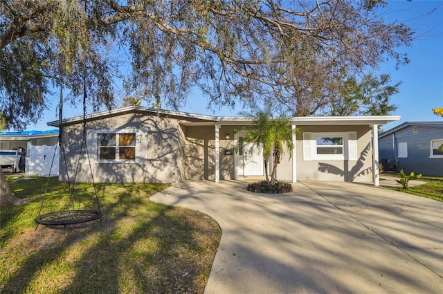 ranch-style home with a carport and a front lawn