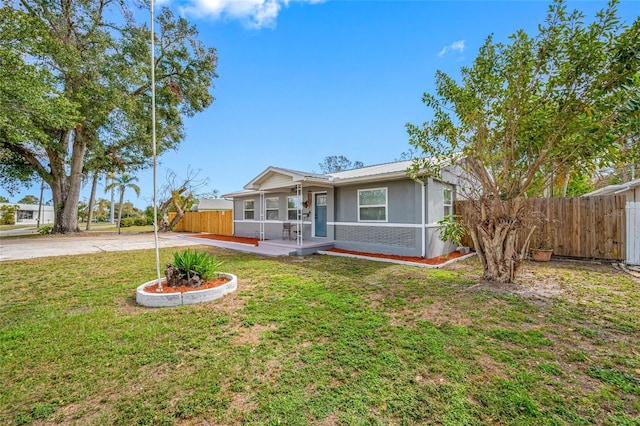 ranch-style house featuring covered porch and a front lawn