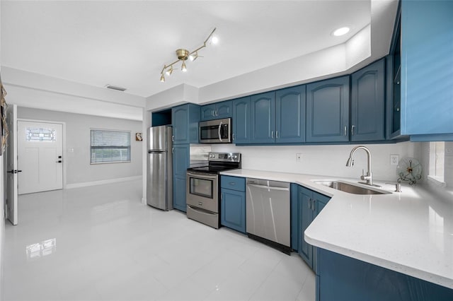 kitchen with sink, blue cabinetry, and appliances with stainless steel finishes