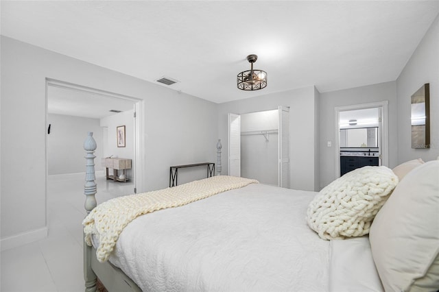 tiled bedroom featuring ensuite bath and a closet