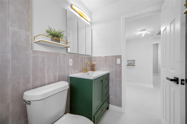 bathroom with vanity, tile walls, and toilet