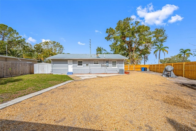 back of house featuring cooling unit and a yard