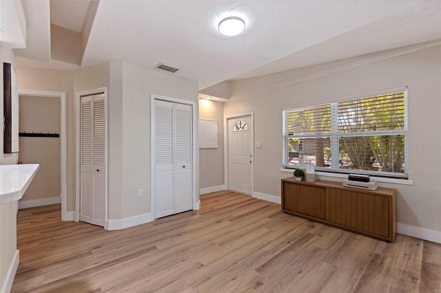 foyer with a textured ceiling and light hardwood / wood-style flooring