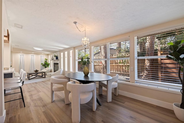 dining room with a textured ceiling, an inviting chandelier, and wood-type flooring