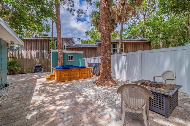 view of patio with a storage unit and a jacuzzi