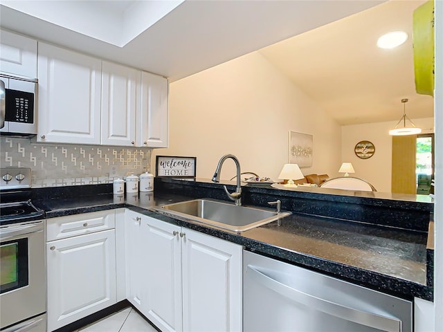 kitchen featuring sink, tasteful backsplash, light tile patterned floors, appliances with stainless steel finishes, and white cabinets