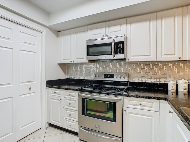 kitchen featuring tasteful backsplash, white cabinetry, appliances with stainless steel finishes, and dark stone counters