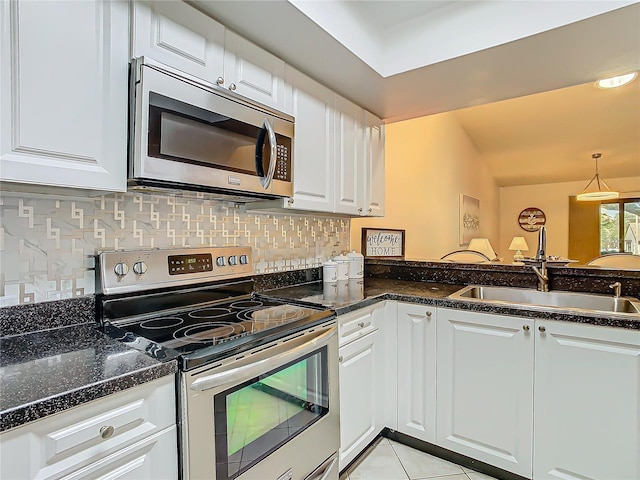 kitchen featuring sink, hanging light fixtures, appliances with stainless steel finishes, white cabinets, and backsplash