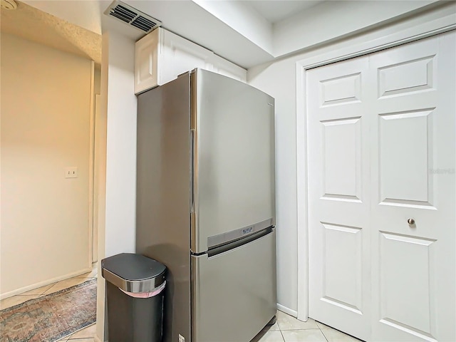 kitchen featuring light tile patterned floors and stainless steel fridge