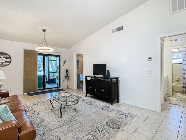 living room with light tile patterned floors and high vaulted ceiling