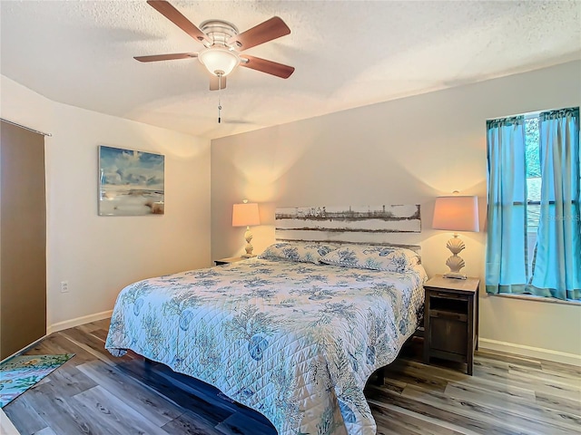 bedroom with wood-type flooring, ceiling fan, and a textured ceiling