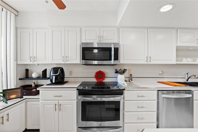 kitchen with stainless steel appliances, ceiling fan, white cabinets, and backsplash