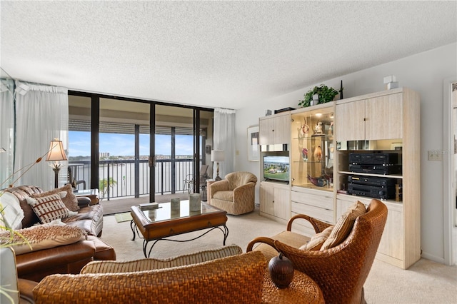 living room with expansive windows, light carpet, and a textured ceiling