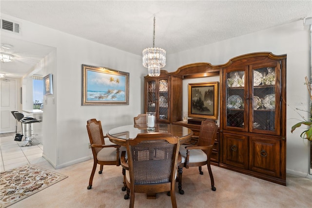 dining area featuring light colored carpet, a notable chandelier, and a textured ceiling