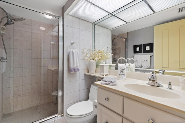 bathroom featuring vanity, an enclosed shower, tile walls, and toilet