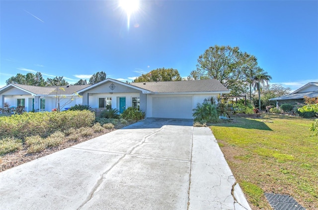 ranch-style home with driveway, stucco siding, an attached garage, and a front yard