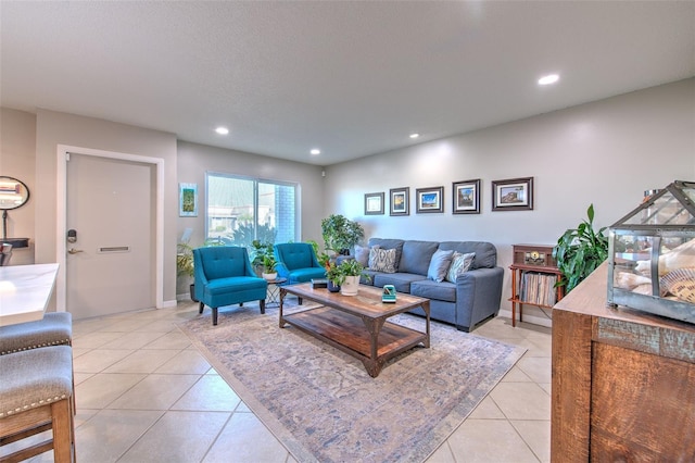 living area with light tile patterned floors, a textured ceiling, baseboards, and recessed lighting