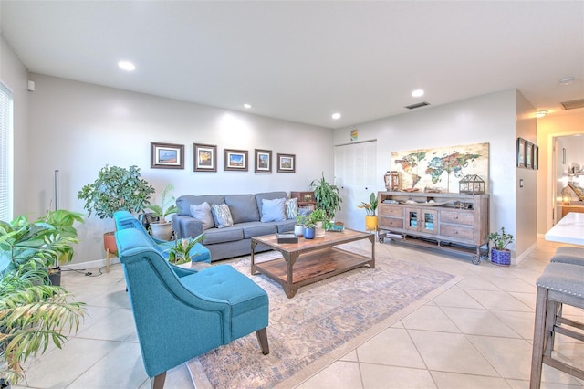 living area with light tile patterned floors, baseboards, visible vents, and recessed lighting