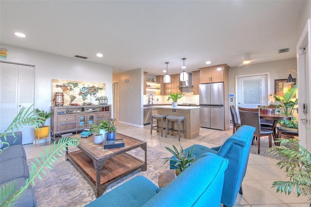 living room with light tile patterned floors, visible vents, and recessed lighting