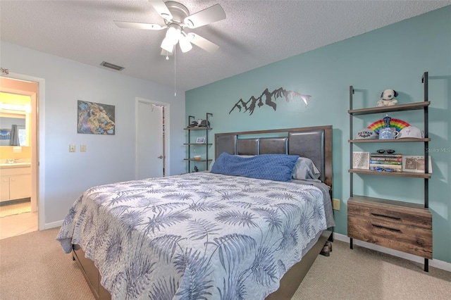 bedroom featuring a textured ceiling, carpet floors, a sink, visible vents, and a ceiling fan