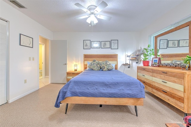 bedroom featuring light colored carpet, visible vents, ceiling fan, a textured ceiling, and baseboards