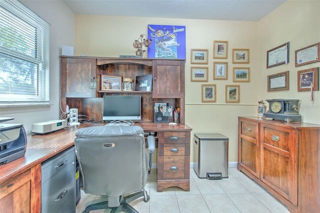 office area with light tile patterned floors and baseboards