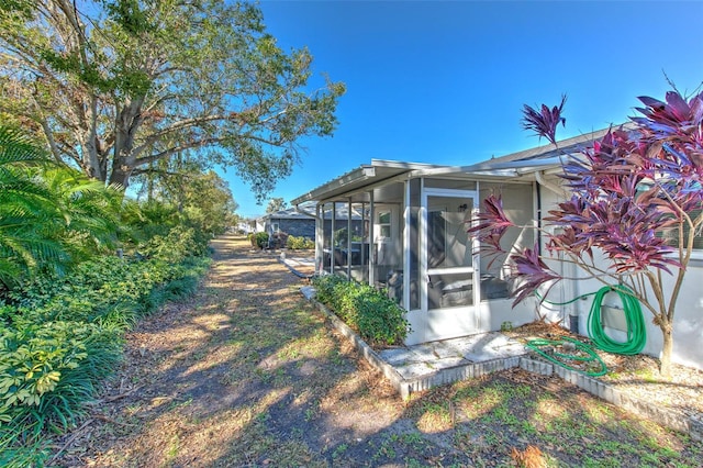 view of property exterior featuring a sunroom