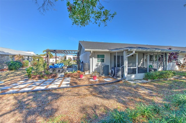 view of front facade featuring cooling unit, a sunroom, and a pergola