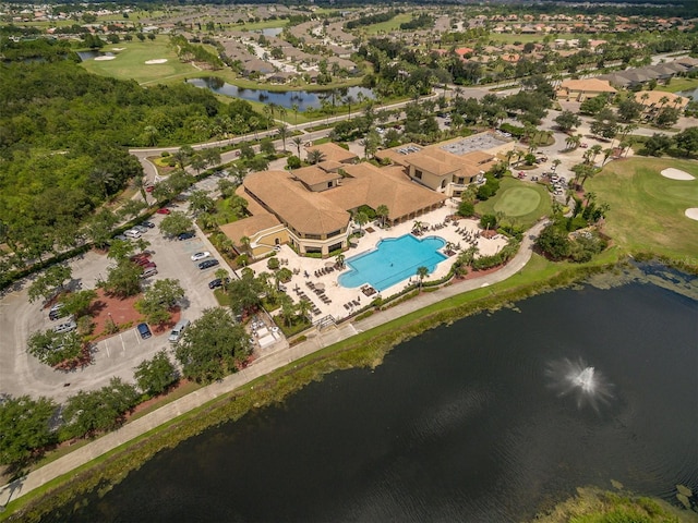 drone / aerial view with view of golf course and a water view