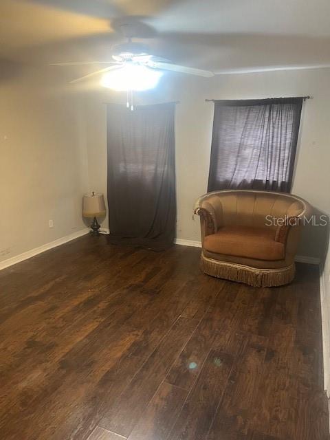 living area featuring ceiling fan, baseboards, and wood finished floors