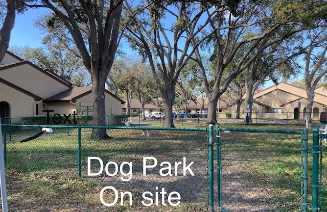 exterior space with a residential view, fence, and a lawn