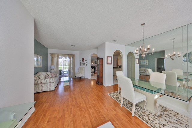 dining space with hardwood / wood-style floors and a textured ceiling