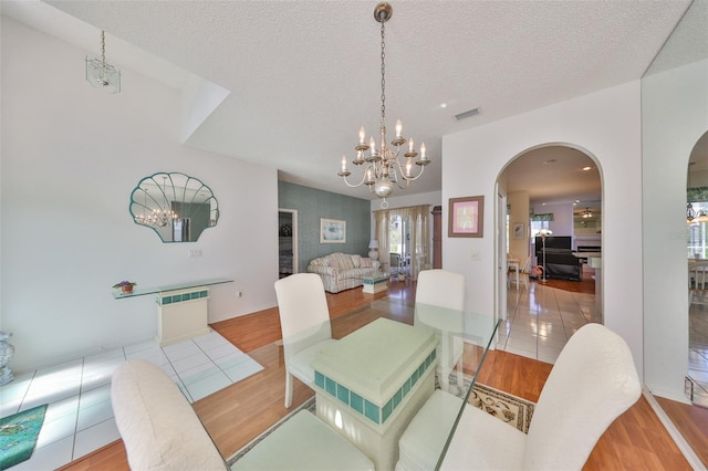 dining room featuring radiator, a textured ceiling, and light wood-type flooring