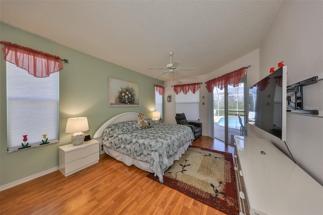 bedroom featuring hardwood / wood-style floors, ceiling fan, access to outside, and a textured ceiling