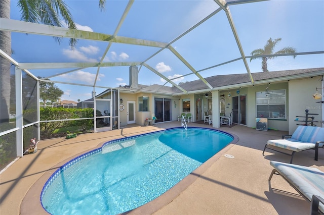 view of swimming pool featuring ceiling fan, a lanai, and a patio area