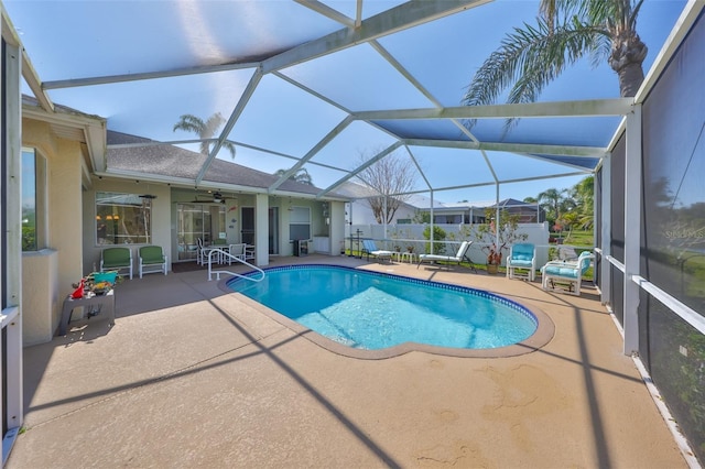 view of swimming pool with a patio, ceiling fan, and glass enclosure