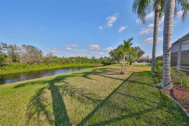 view of yard featuring a lanai and a water view