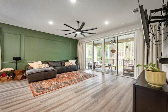 living room with ceiling fan and light wood-type flooring