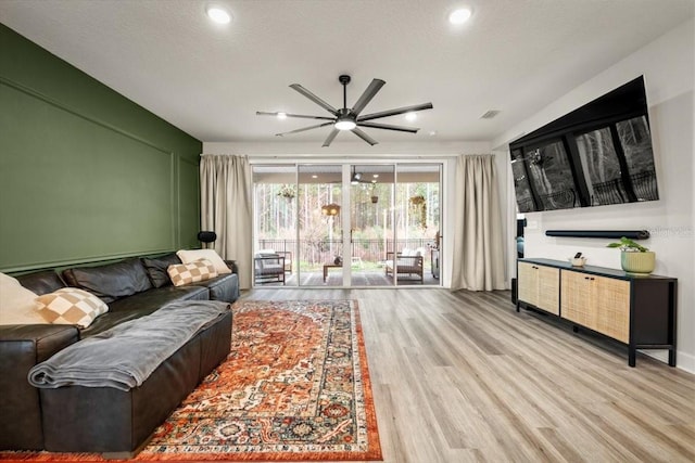 living room with a textured ceiling and light hardwood / wood-style flooring