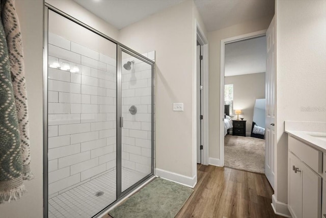 bathroom with vanity, a shower with shower door, and hardwood / wood-style floors