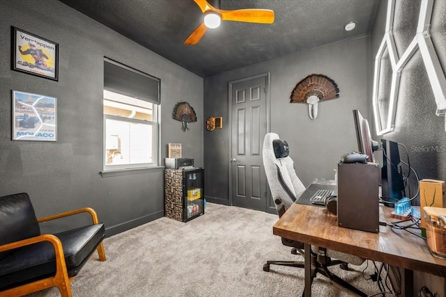 carpeted office space featuring ceiling fan and a textured ceiling