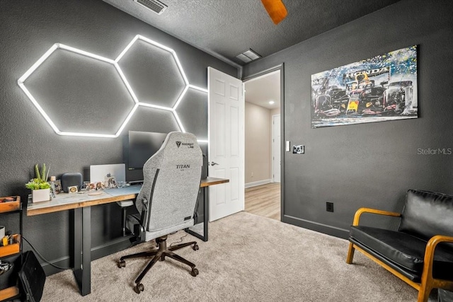 carpeted home office with a textured ceiling