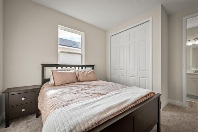 carpeted bedroom featuring ensuite bath and a closet