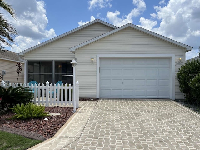 view of front facade featuring a garage and a sunroom