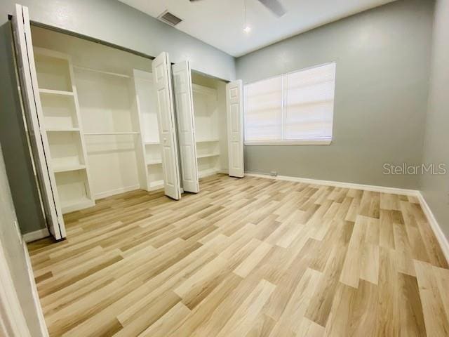 1829 10th St N, Saint Petersburg, FL 33704 - unfurnished bedroom with two closets, ceiling fan, and light wood-type flooring