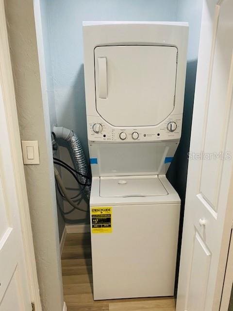 1829 10th St N, Saint Petersburg, FL 33704 - clothes washing area featuring stacked washer / drying machine and light hardwood / wood-style flooring