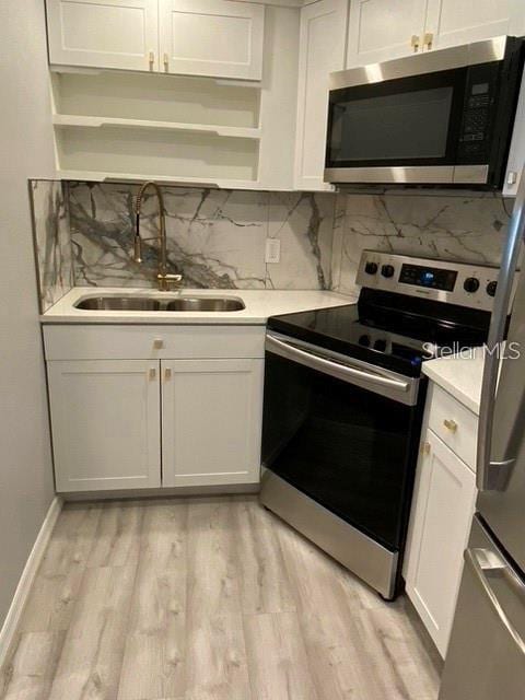 1829 10th St N, Saint Petersburg, FL 33704 - kitchen featuring white cabinetry, sink, and appliances with stainless steel finishes