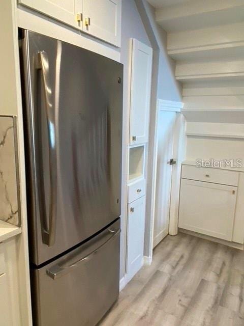 1829 10th St N, Saint Petersburg, FL 33704 - kitchen with stainless steel refrigerator, white cabinetry, and light hardwood / wood-style flooring
